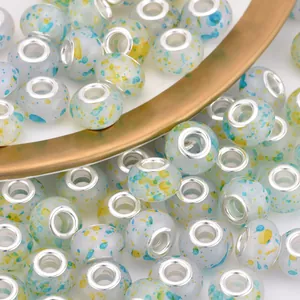 Macro shot of ink-splattered large hole resin beads with silver metal cores
