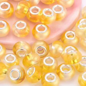 Macro shot of yellow resin rainbow beads with gold powder and silver metal core