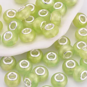 Primer plano de cuentas de resina verde claro con purpurina para joyería artesanal