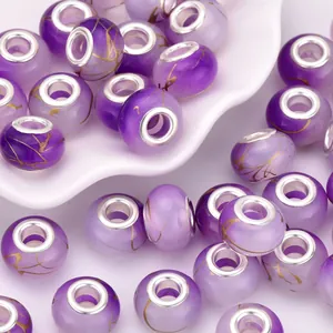 Detail of purple resin beads with gold leaf patterns and large silver metal core holes