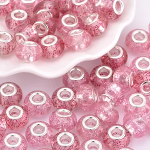 Macro shot of pink glitter resin beads with large metal holes for DIY jewelry