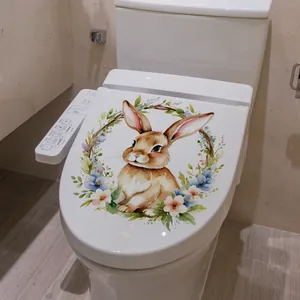 Détail d'un autocollant de lapin de Pâques à l'aquarelle avec couronne sur WC blanc