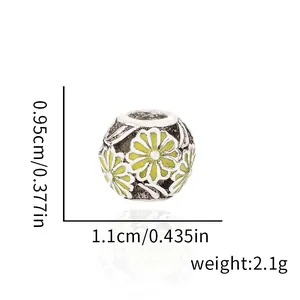 Detailed view of yellow enamel daisy charm bead with 1.1cm width and 2.1g weight