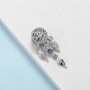 Detailed shot of silver dreamcatcher charm with tree of life and purple gemstone bead