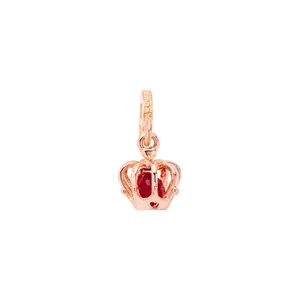 Rose gold crown charm with faceted red gemstone and heart-shaped hollow details