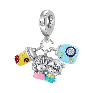 Detail view of colorful enamel charms featuring a cup, cartoon figures, and a camera