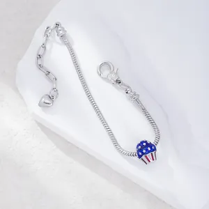 Silver snake chain bracelet with USA flag themed cupcake charm and heart pendant charm
