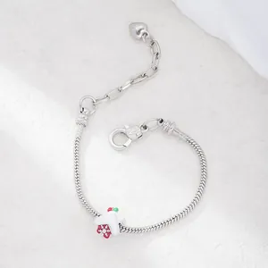Silver snake chain bracelet featuring a red Christmas house charm with snowflake patterns