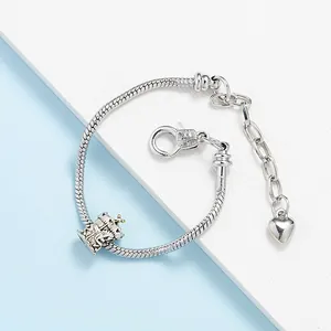 Silver snake chain bracelet with a detailed castle charm and heart-shaped pendant