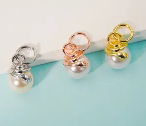 Detailed view of snake-wrapped pearl pendants in gold, silver, and rose gold finishes
