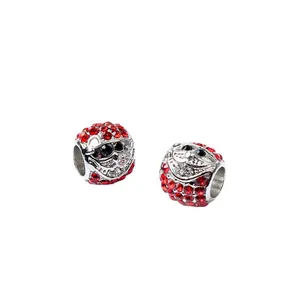 Detail van twee Kerstman-bedeltjes met rode strass-steentjes voor DIY-armband