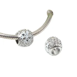Macro-opname van zilveren sneeuwvlokbedel met witte kristallen voor DIY-armbanden