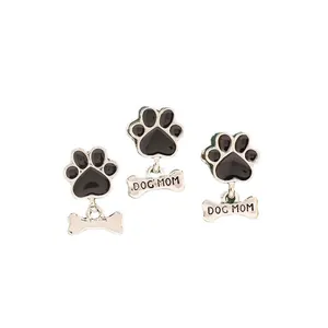 Detail of silver alloy dog paw charms with black enamel and Dog Mom bone pendants