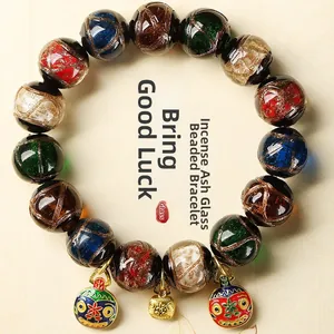Macro shot of colorful glass beads with golden blessing bag and enamel mask charms
