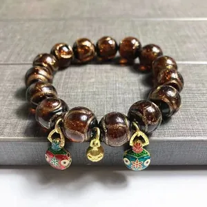 Amber glazed bead bracelet with golden gourd and enamel flower bell charms