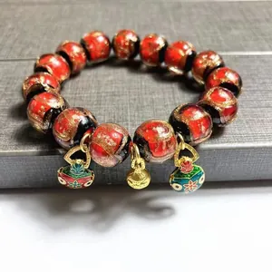 Ethnic style glass bead bracelet with red black gold textures and enamel pendants