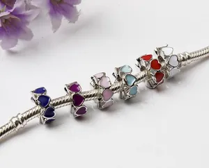 Macro shot of colorful enamel heart beads on a silver snake chain charm bracelet