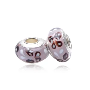 Macro shot of purple glass charms with floral patterns and S925 silver core hallmark