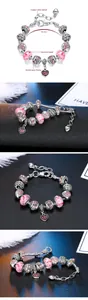 Detail view of pink crystal heart charms and silver-plated snake chain bracelet