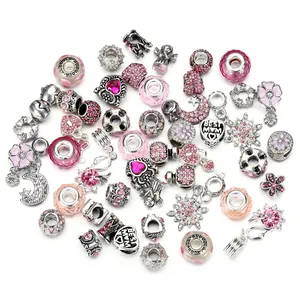 Detailed macro of pink glass charms and silver heart pendant with Best Mom engraving