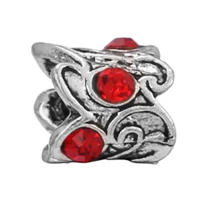 Retro silver alloy charm with red rhinestones and vintage embossed scroll patterns