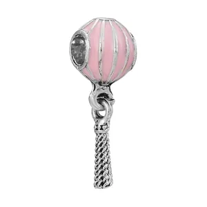Detailed close-up of a pink enamel hot air balloon charm with silver woven basket detail