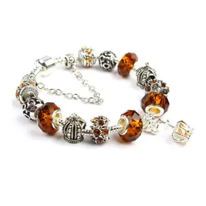 Macro view of crystal beaded bracelet with amber glass beads and crown charms