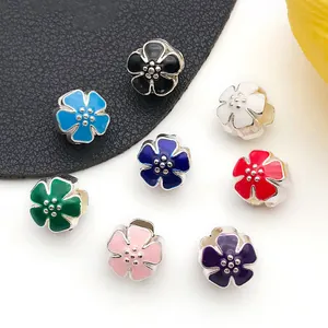 Macro shot of assorted colorful floral enamel charms with silver-tone metal bases