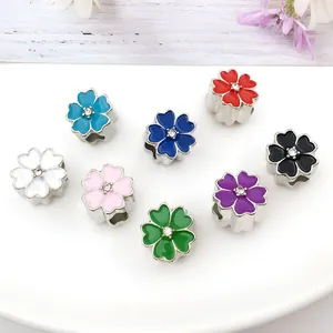 Macro shot of colorful enamel flower beads with sparkling crystals for DIY jewelry making
