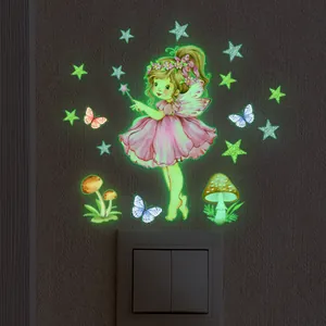 Luminous wall stickers featuring fairy, stars, and mushrooms on dark wall near light switch