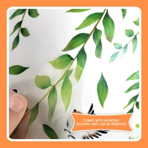 Macro view of self-adhesive PVC wall sticker showing easy removal of green leaves design