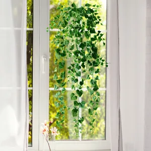 Realistic artificial ivy hanging plants with heart-shaped leaves on a white window