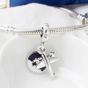 Macro shot of silver airplane charm with blue enamel on a snake chain bracelet