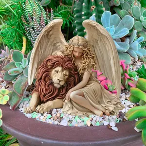Detailed close-up of a resin angel and lion figurine placed in a succulent garden bed