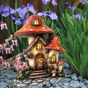 Detailed view of mushroom house garden statue with LED light in outdoor flower bed