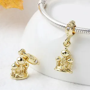 Detail of a golden castle charm with crystal inlay and beadwork for bracelets