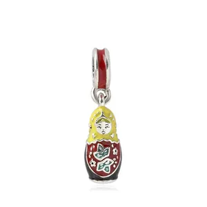 Close-up of colorful enamel Russian doll charm with detailed floral patterns and red scarf