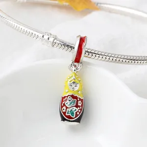 Macro shot of Russian Matryoshka doll charm with colorful enamel on a silver snake chain
