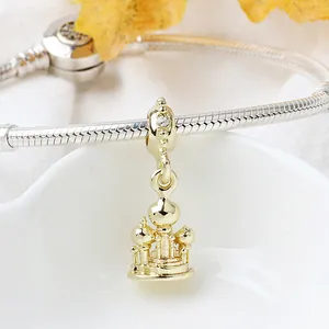 Macro shot of gold castle charm with white zircon on silver snake chain bracelet