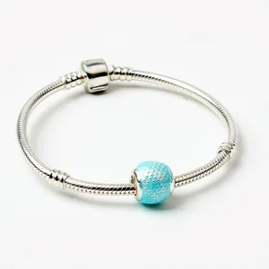 Detalle de pulsera de cadena de serpiente plateada con cuenta azul cielo texturizada