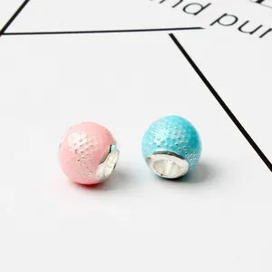 Detalle de cuentas para joyería rosa y azul con textura de puntos y núcleos metálicos