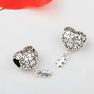 Vue détaillée des pendentifs cœur puzzle en argent vintage avec texture métallique