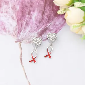 Detail of silver heart pendants with pave diamonds and red enamel awareness ribbon symbols