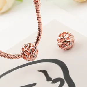 Close-up of rose gold snake chain bracelet with hollow charm and sparkling zircon stones