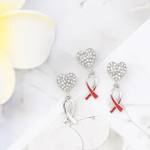 Detailed macro view of heart-shaped diamond-encrusted pendants with red ribbon accents