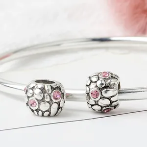 Silver bracelet with pink crystal pavé round beads featuring textured relief details