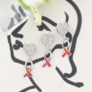 Close-up of sparkling heart charms with red ribbon symbols on white background