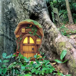 Detail of tree house fairy door garden ornament with wood texture and orange flowers