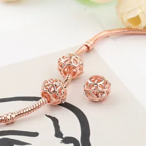 Rose gold charm bracelet featuring hollow weave charms and sparkling white zircons