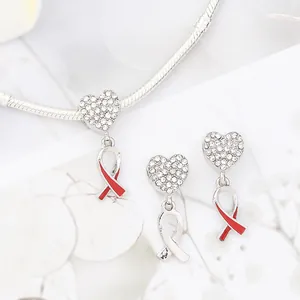 Glittering cross pendant jewelry set with shimmering crystals and red ribbon accents